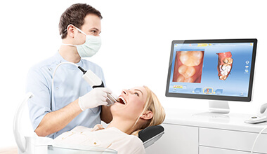 dentist taking CEREC digital bite impressions of smiling woman's teeth