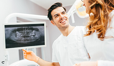 Smiling man and woman viewing digital x-rays