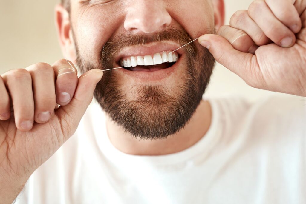 A man flossing his teeth